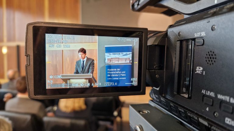 Display einer Videokamera zeigt einen Redner am Pult der Akademie der Wissenschaften und der Literatur Mainz