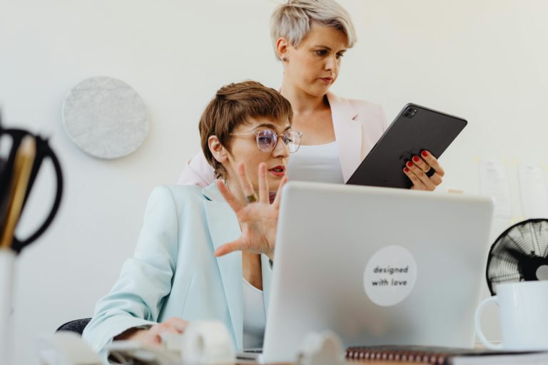 Zwei Frauen arbeiten gemeinsam an Laptop und Tablet