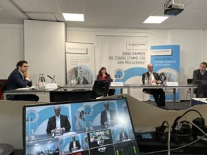 Podium der hybriden Pressekonferenz der Landespflegekammer mit Bildschirm für zugeschaltete Gäste
